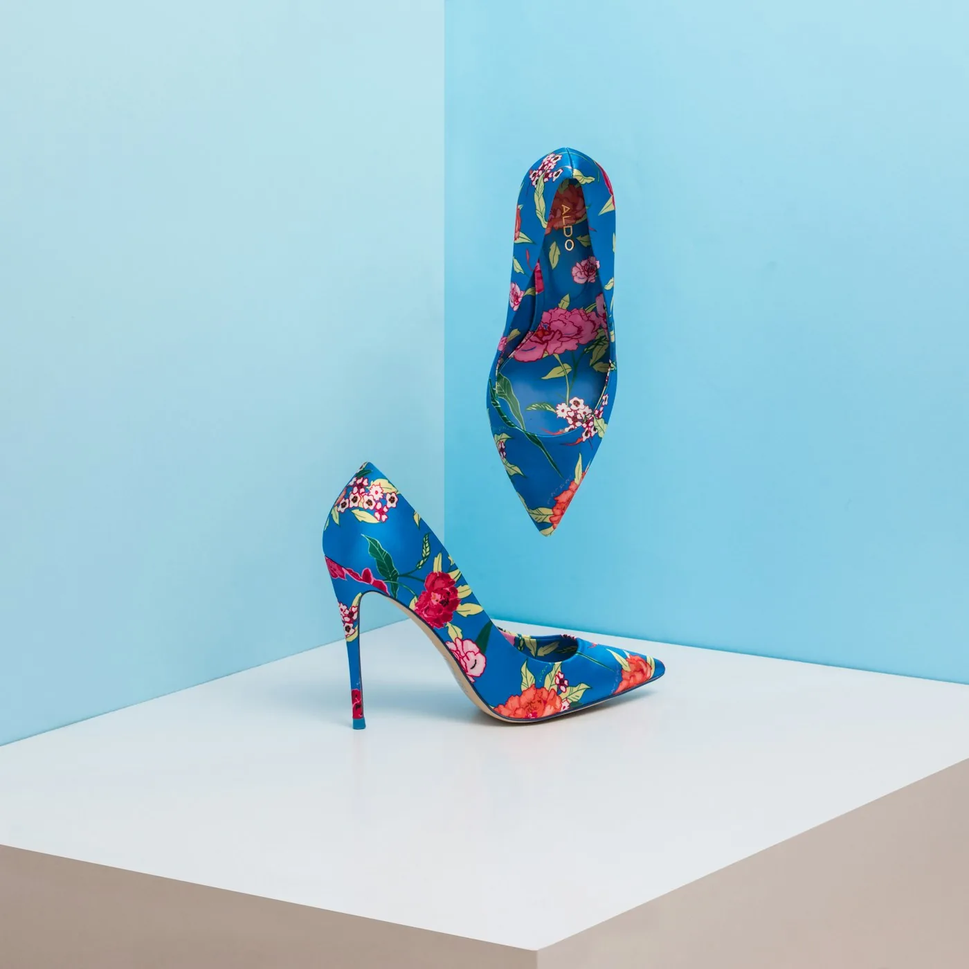 Floral high-heeled shoes against a blue background