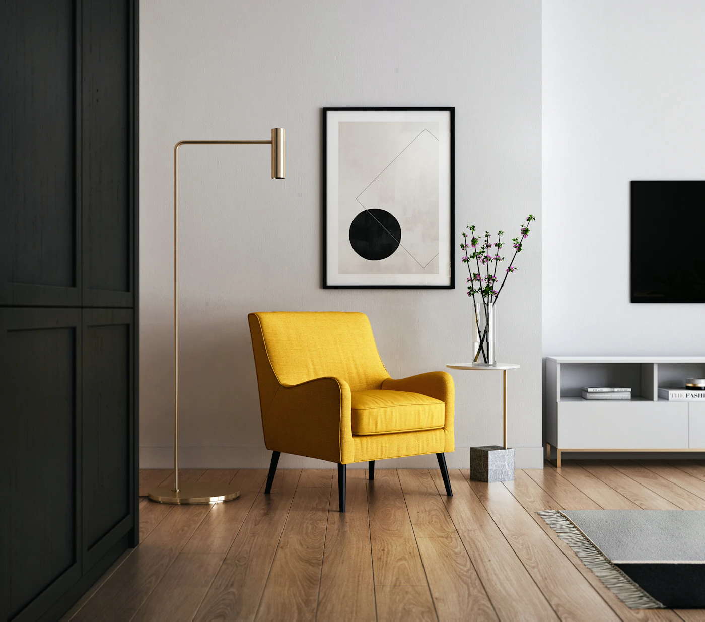 A yellow upholstered chair beside a floor lamp and framed graphic artwork.