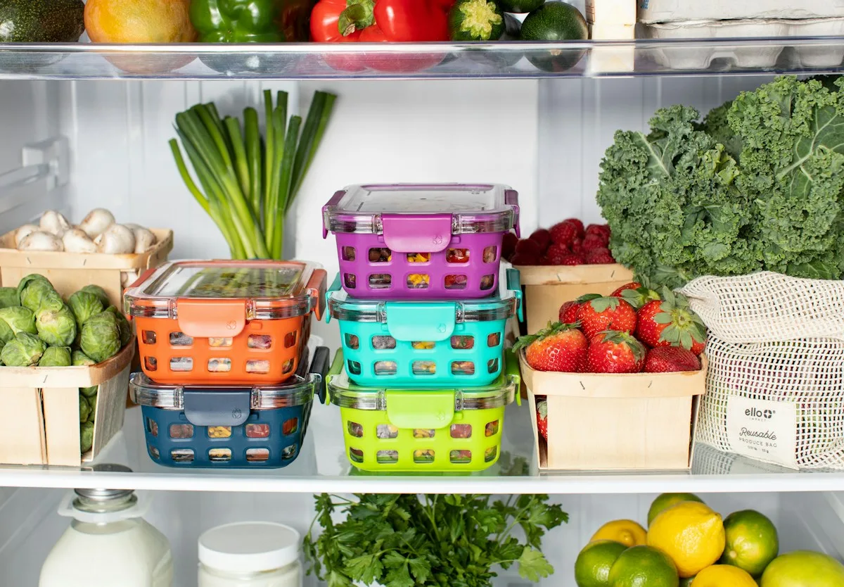 Brightly coloured food baskets and fresh produce on refrigerator shelves.