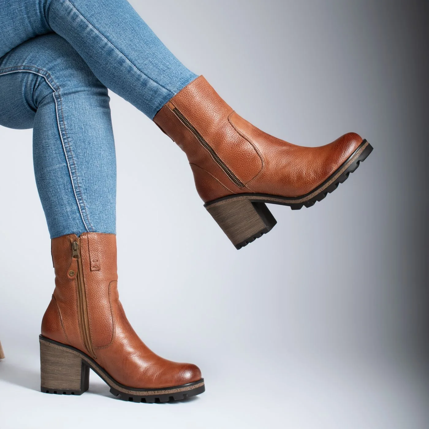 Brown ankle boots with block heels worn with blue jeans.